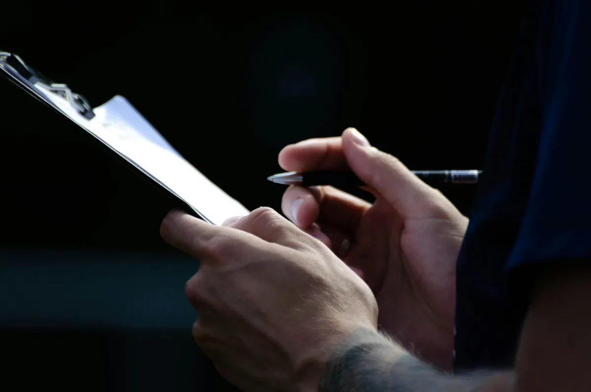 Auditor tomando notas en una planilla durante un relevamiento de seguridad